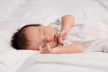 Fototapeta na wymiar Cute newborn baby sleeping on white bed