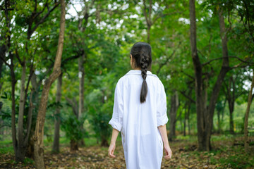 Naklejka premium Happy woman in forest with open arms from behind breathing clean air. Environment, no pollution healthy natural living lifestyle. Free spirit in the woods.