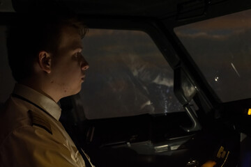Captain with firm grip on controls during night flight. Professional man pilot deftly maneuvers...
