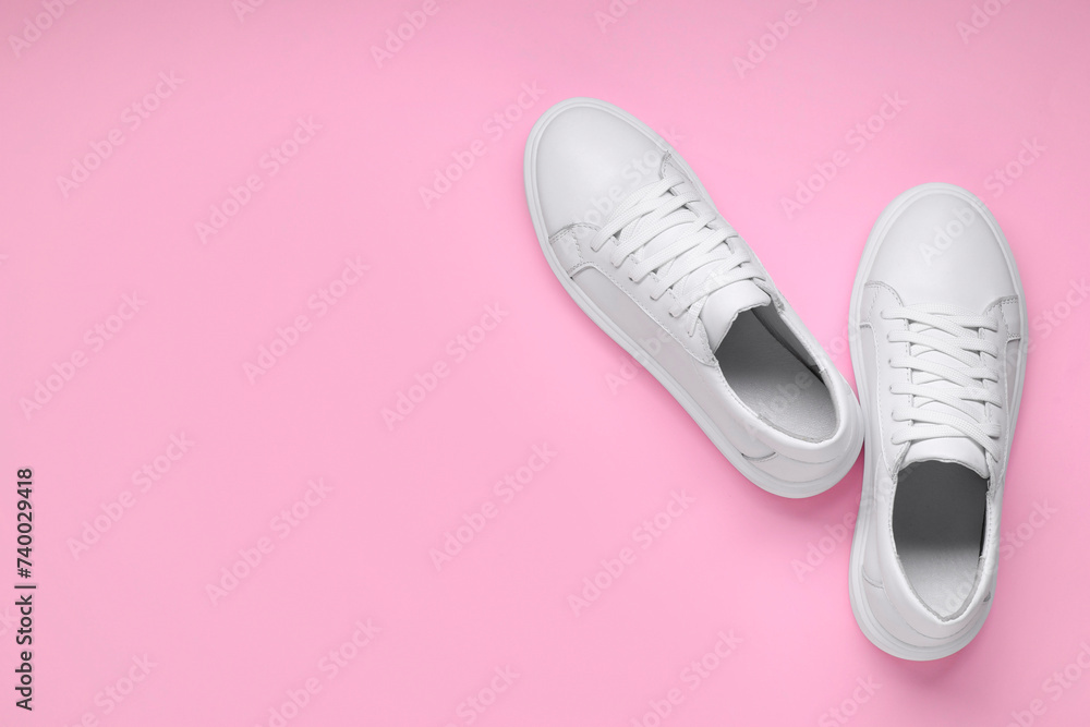 Sticker Pair of stylish white sneakers on pink background, top view. Space for text