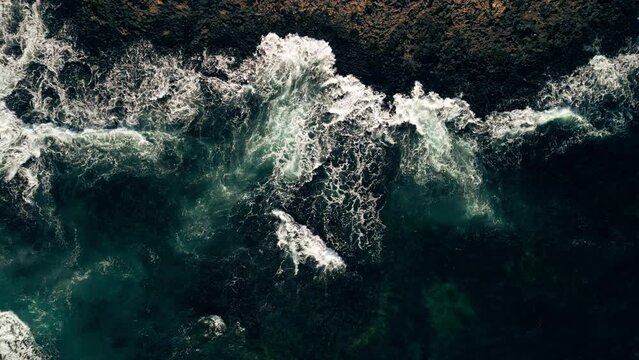 Blue waves of the Atlantic Ocean near the Faro de Toston lighthouse in the Canary Islands. The sea coast of the volcanic island of Fuerteventura surrounded by the sea waves of the Atlantic Ocean, sea 