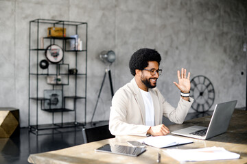 Engaged in a virtual conversation, a Brazilian businessman gestures during an online meeting,...