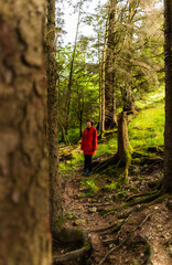 Tranquil Highland Stroll: A Portrait of Graceful Independence, A Woman in Red Coat, Amidst Serene Forests of Scotland's Summer Day Exploration