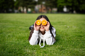 child with orange on green grass