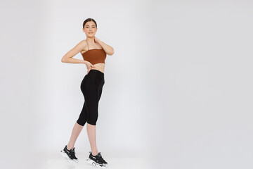 Attractive young adult in sportswear posing on white background.