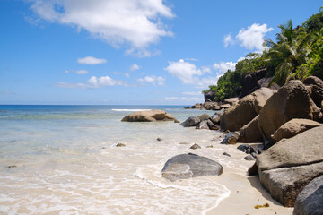 Granite gray rocks on the famous beach of Anse Coco with blue tropical water and amazing sky in Mahe Island. Seychelles - Powered by Adobe