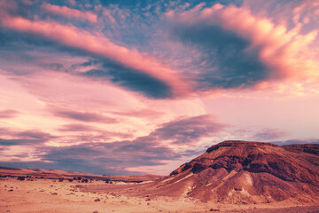 Evening cloudy sky over mountain desert. Negev desert in Israel at sunset