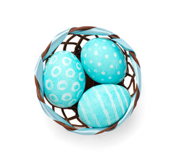 Blue painted easter egg in basket isolated on white, top view