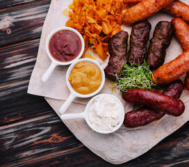 Beer set of grilled sausages with stewed cabbage and sauces
