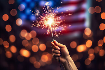 Hand holding USA flag in celebration with sparkler fireworks in the background. - Powered by Adobe