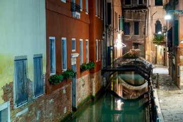 Enge Gassen und Kanäle in Venedig bei Nacht, ohne Personen.