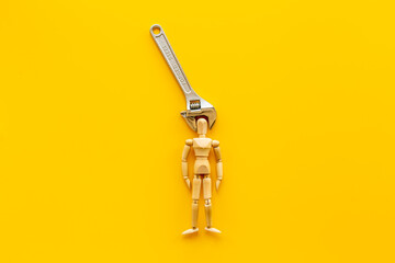 Head in pliers - headache and migraine concept. Wooden figurine of a man with pliers - obrazy, fototapety, plakaty