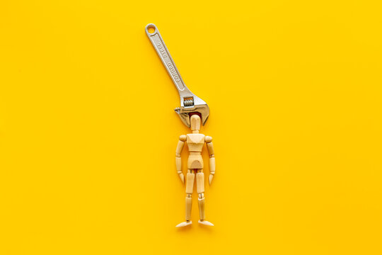 Head in pliers - headache and migraine concept. Wooden figurine of a man with pliers