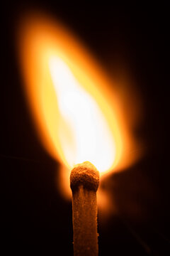 Close-up view of a matchstick that has just been ignited, with the flame brightly burning at its tip.