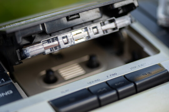 Close-up view of an old-fashioned cassette player with a cassette tape and its case.