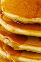 A stack of pancakes with honey on a vintage plate on the table. Breakfast.