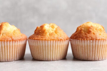 Tasty muffins on light grey table, closeup. Fresh pastry