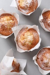 Delicious muffins on grey table, flat lay