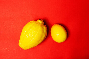 Juicy ripe lemons on a red background. A creative food concept. Tropical organic fruits, citrus...