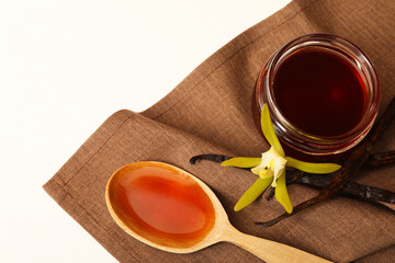 Aromatic vanilla extract, pods and flower on white table, top view