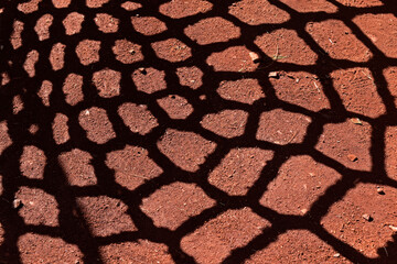 Naklejka premium Rope net shadow detail on red soil in playground