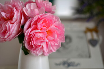 romantyczna rózowa roza w białym wazonie na stoliku, romantyczne tło, rózowa róza w wazonie, róza i ramka ze zdjęciem, romantic pink rose in a white vase on the table, romantic background	 - obrazy, fototapety, plakaty