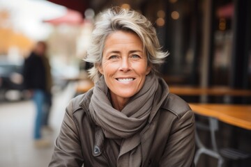 Fototapeta premium Portrait of a happy senior woman in a cafe on the street