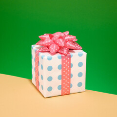 A large gift with a bright pink bow on a green background. Colorful celebration design.