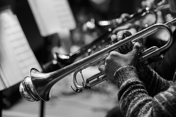 Trumpet in the hands of a musician in an orchestra in black and white - 740087622