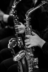  Hands of a girl playing the saxophone in an orchestra in black and white