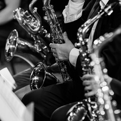 A fragment of a saxophone in the hands of a musician in an orchestra in black and white - 740087653