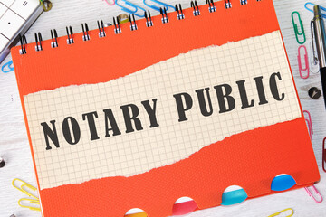 NOTARY PUBLIC is written on a piece of paper in a cage on the background of an orange notebook cover
