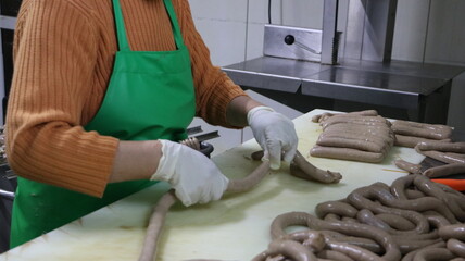 Worker in food industry making artisanal sausages