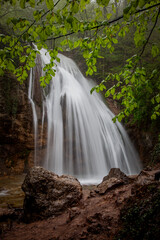 Obraz premium Beautiful waterfall in the forest among green trees