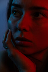 portrait photo of a woman in red neon light. Pensive lonely woman.
