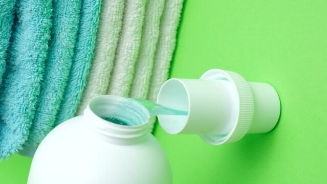 The process of pouring natural eco gel liquid laundry detergent from the bottle into the cap, vertical shoot