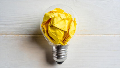 Crumpled paper in a light bulb as idea concept isolated on white background; symbol of an intelligent man
