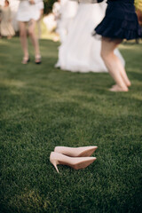 Fashionable brand shoes lie on a green lawn. Party, uncomfortable shoes off