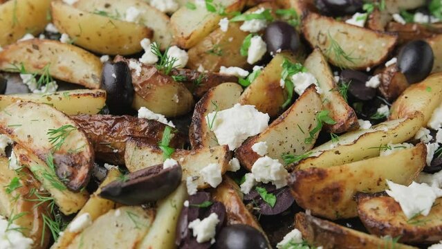 Greek fried potatoes with feta cheese, kalamata olives and parsley and dill. Rotating video