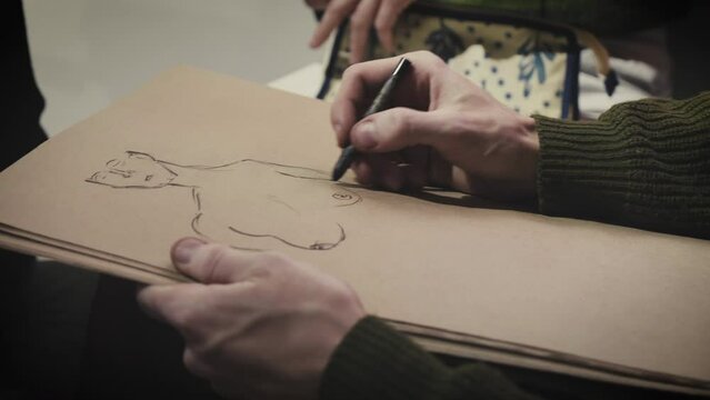 The painter draws a sketch on paper
