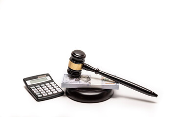 An isolated image of a judge's gavel on a stack of cash with a calculator, signifying legal fines or bail.