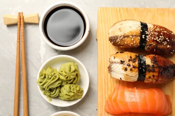 Delicious nigiri sushi, soy sauce, wasabi, ginger and chopsticks on light grey marble table, flat...