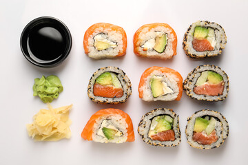 Delicious sushi rolls on white background, flat lay