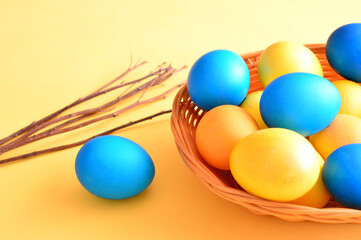 yellow and blue painted eggs on the yellow background