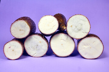Fresh Organic Cassava Root, Manioc Esculenta, yuca On purple Background