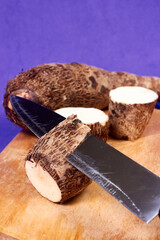 closeup of taro root vegetable, eddo malanga, purple background