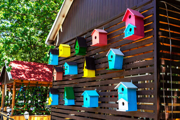 Colorful creative wooden nesting boxes birdhouse hanged on a wall in backyard