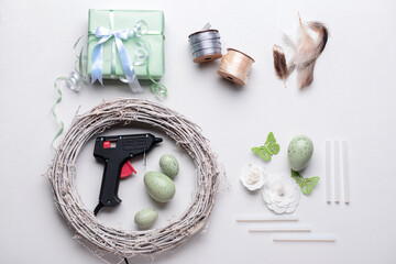 Composition with supplies for creating Easter wreath on white table