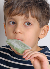 Little kid eating green ice popsicle - 740125257