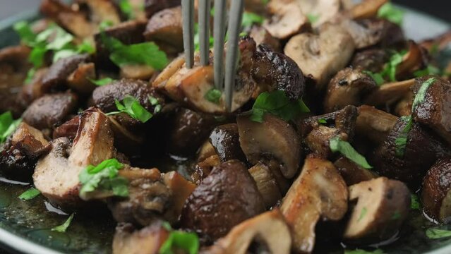 Eating Delicious fried mushrooms with herbs and parsley.